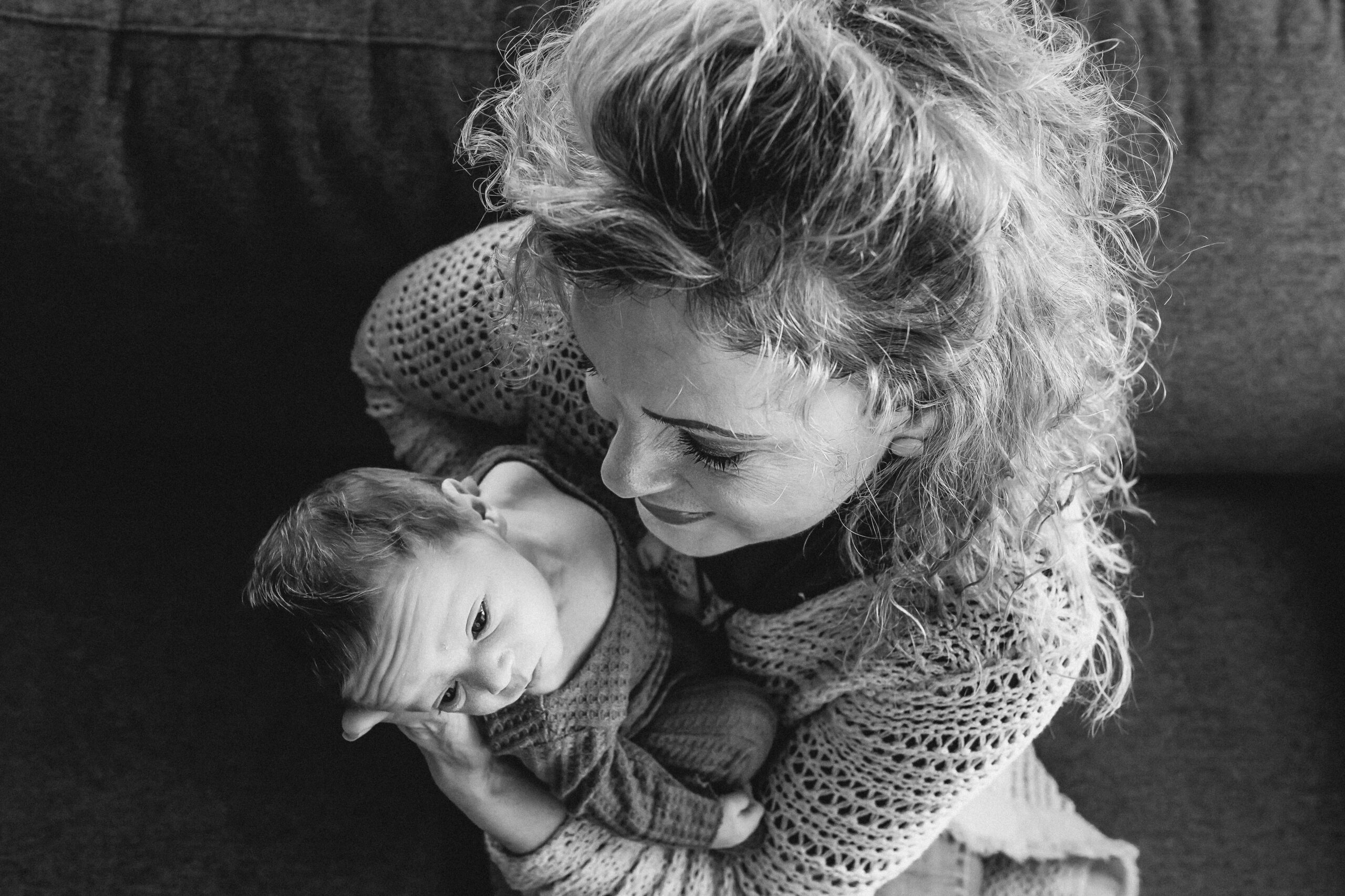 A grandma holds her grandson and looks at him with love