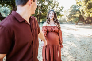 Husband and pregnant wife hold hands