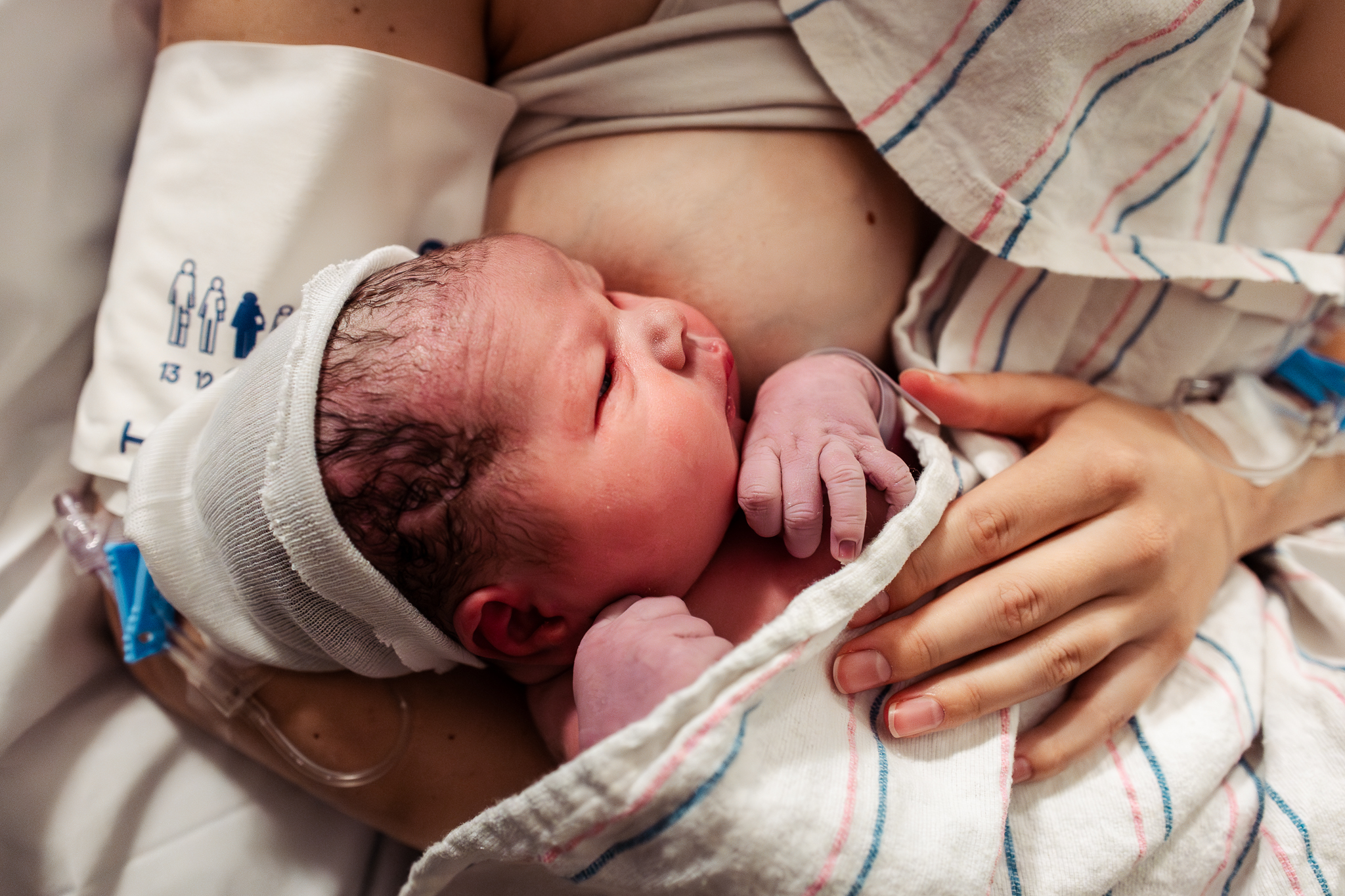 newborn baby lays on mom's belly after birth