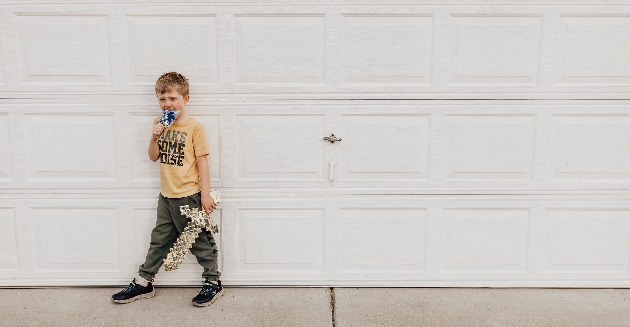 is your child showing signs of autism? this cute child is standing against a white garage door, wearing a yellow shirt and grey pants, and not looking at the camera