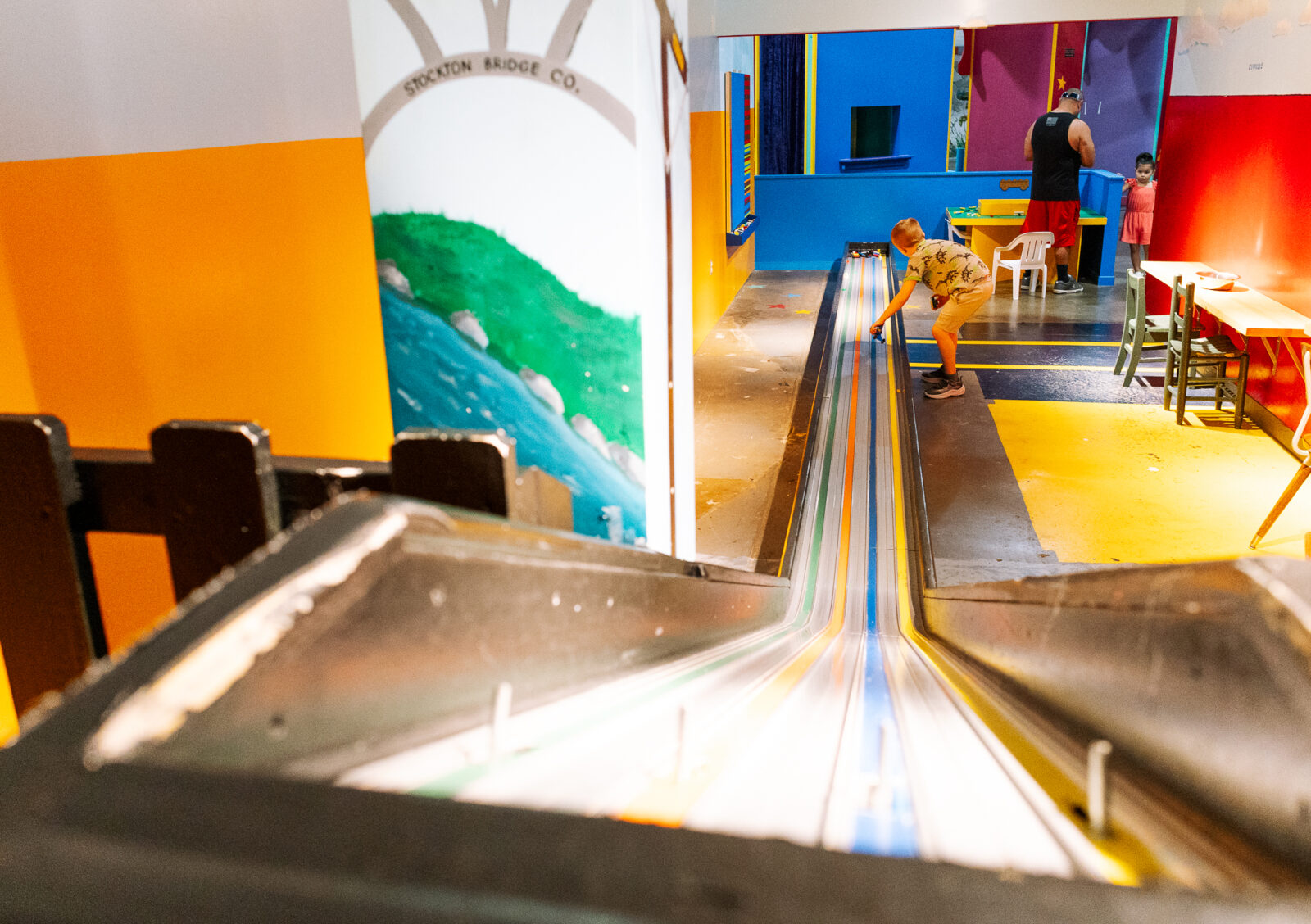 A little boy races cars down an indoor lego race track in Stockton. If you are too hot to play outside, come play in Modesto's best indoor play areas!